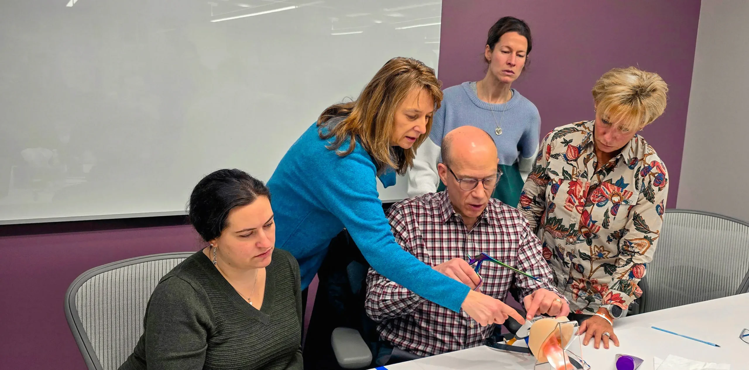 A group of colleagues examine a prototype.